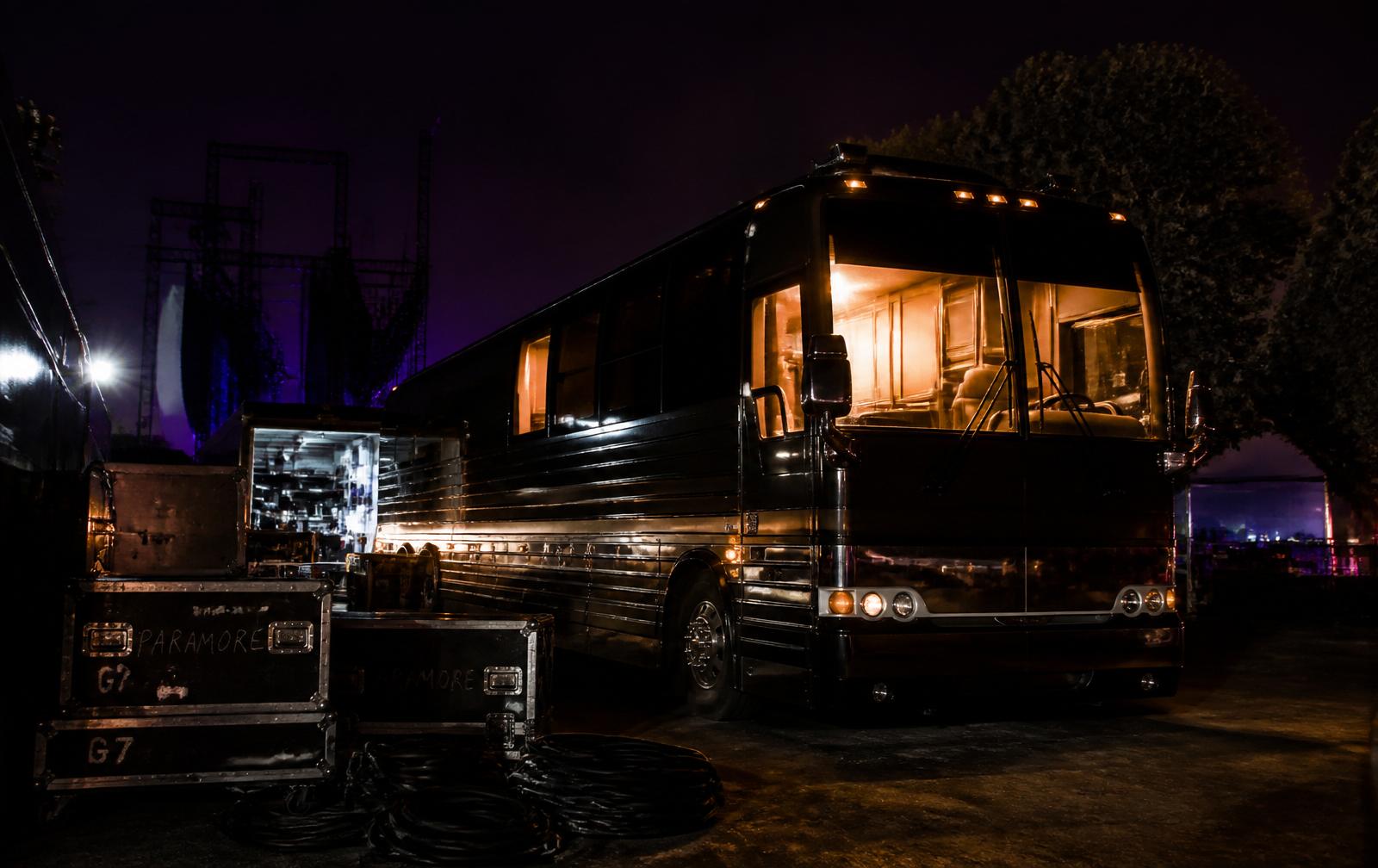 Tour bus and road cases backstage at night