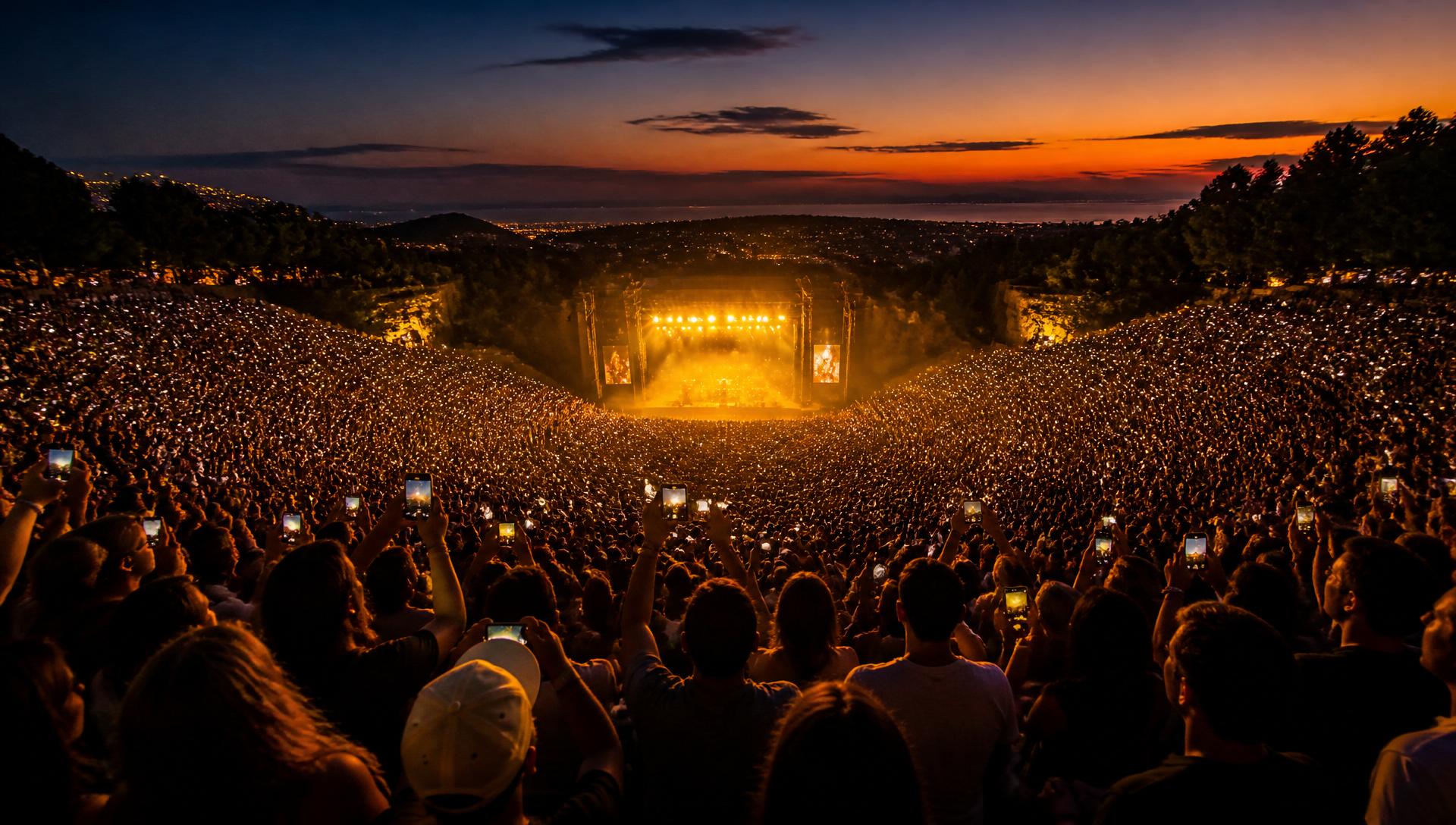Sold-out amphitheater at dusk with a sea of fans